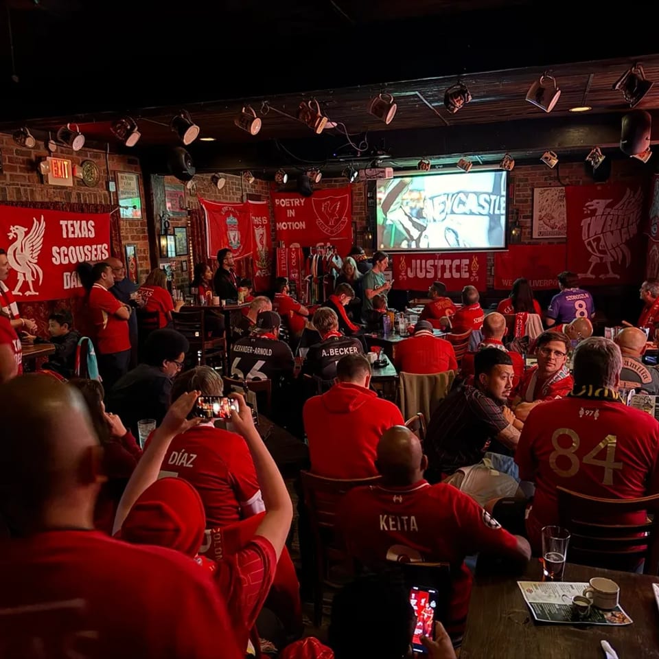 Liverpool supporters watching a match together inside The Londoner.